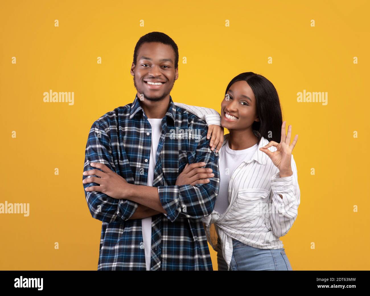 Young cheerful african american female in casual put her hand on guys shoulder Stock Photo