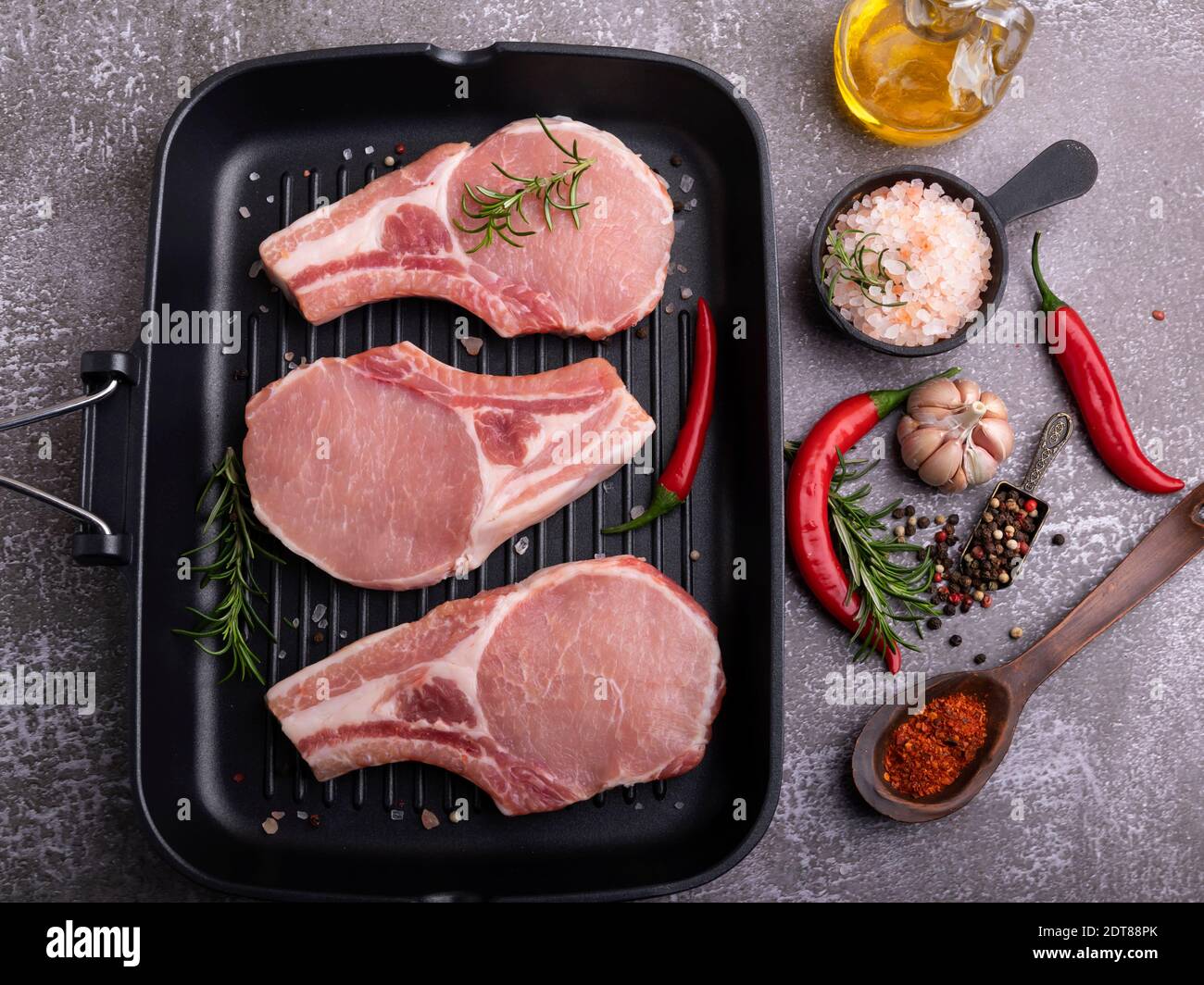 fresh raw meat pork, beef, chop on a bone, on grill pan, spices Stock Photo