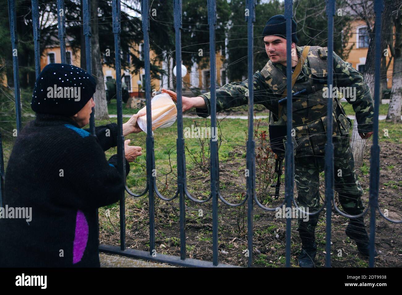 A woman gives food to a Ukranian soldier standing guard inside the Ukranian base in Simferopol. Simferopol, Ukraine, on March 19, 2014. Tensions are rising in Crimea after pro-Russia forces seized two naval bases including Ukraine's navy HQ. Russia has called on authorities there to release the detained commander of the Ukrainian navy. Photo by Rafael Yaghobzadeh/ABACAPRESS.COM Stock Photo