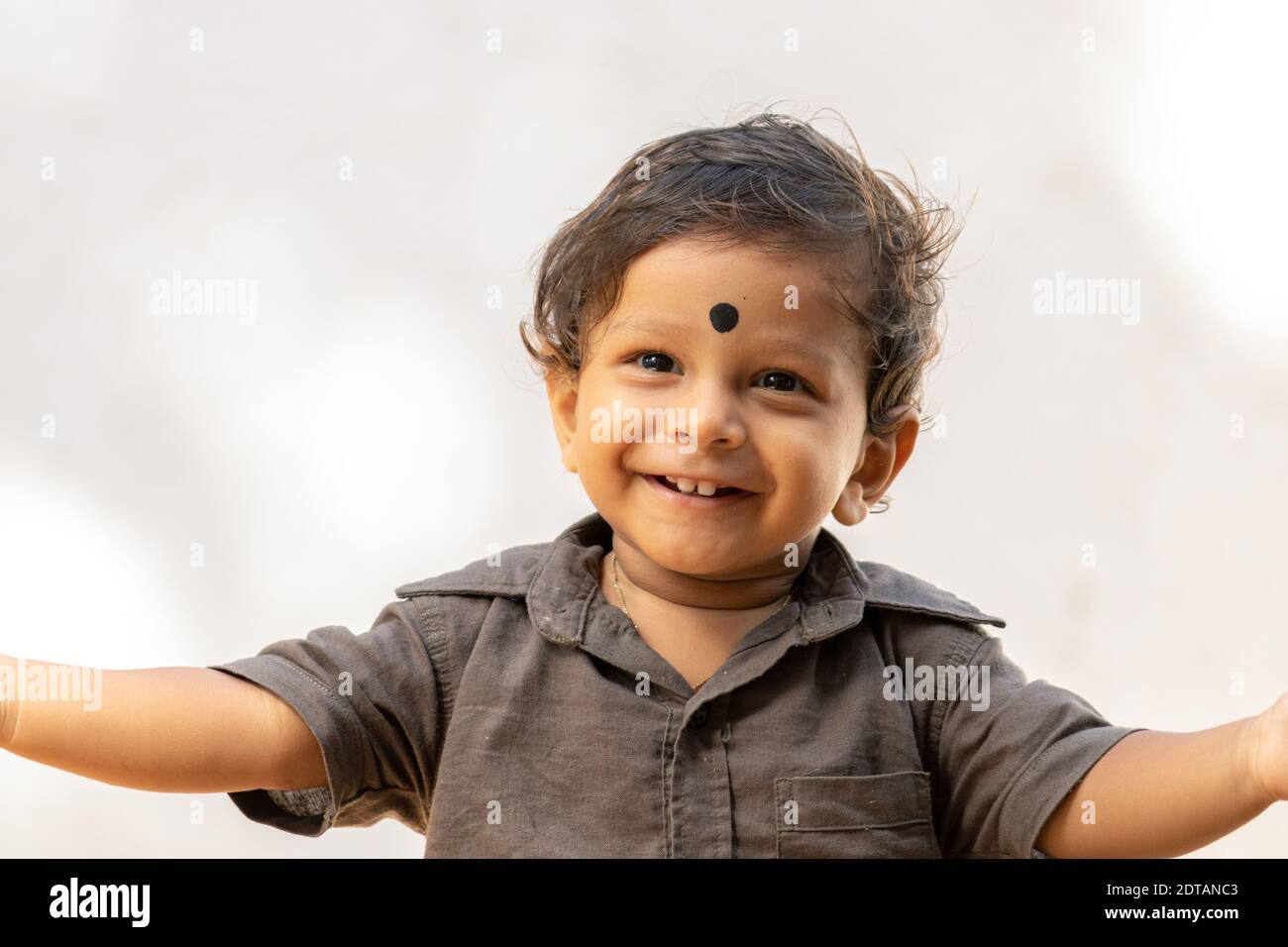 1 year old birthday boy arm raised with a dot in his forehead smiling , happiness of the kids concept. Stock Photo