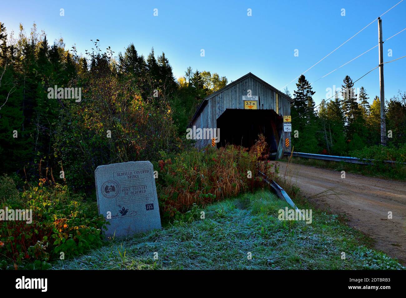 An early morning landscape image of the Oldfields covered bridge with the dedication stone declaring this area a park, near Smith Creek New Brunswick Stock Photo