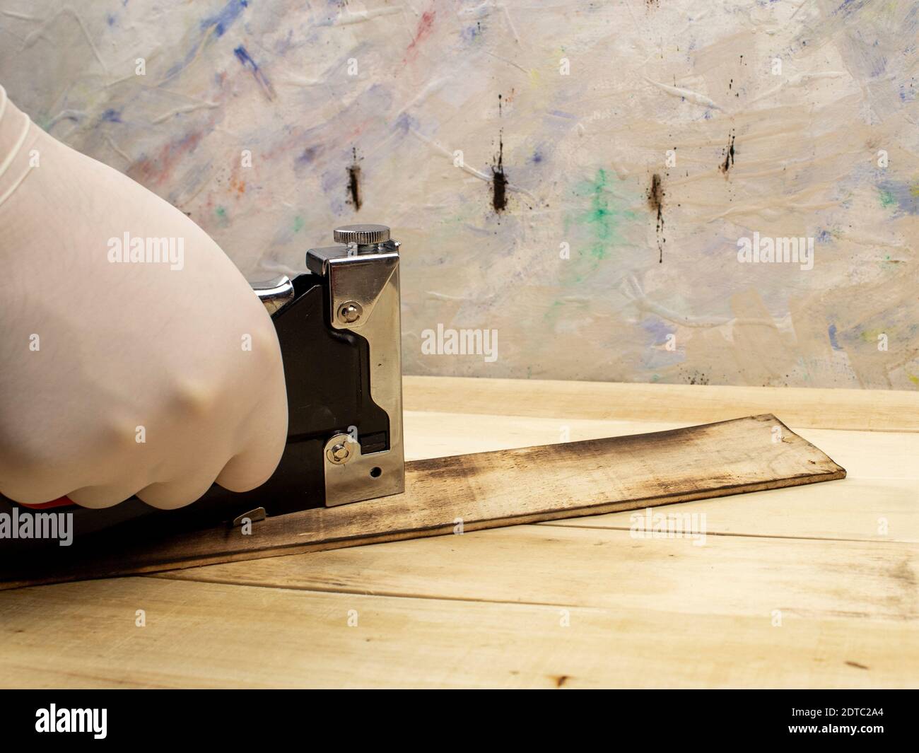 Man fastens boards with a stapler Stock Photo