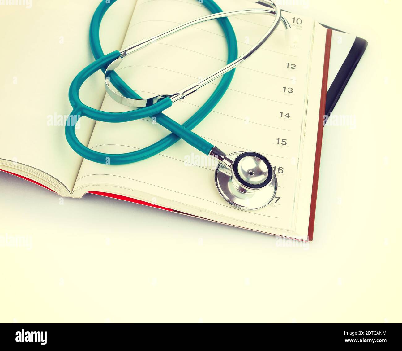 High Angle View Of Stethoscope With Diaries Against White Background Stock Photo