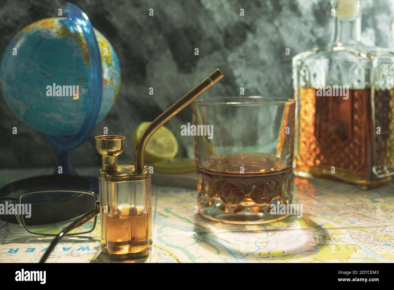 Hookah and bong on a world map. Light through the window illuminates