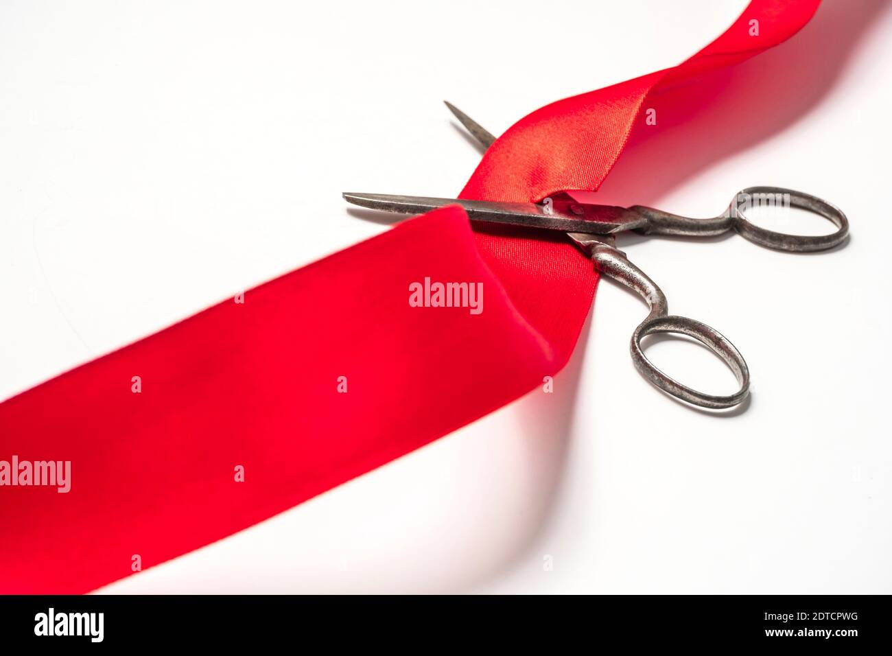 Studio shot of old fashioned scissors cutting red ribbon Stock Photo