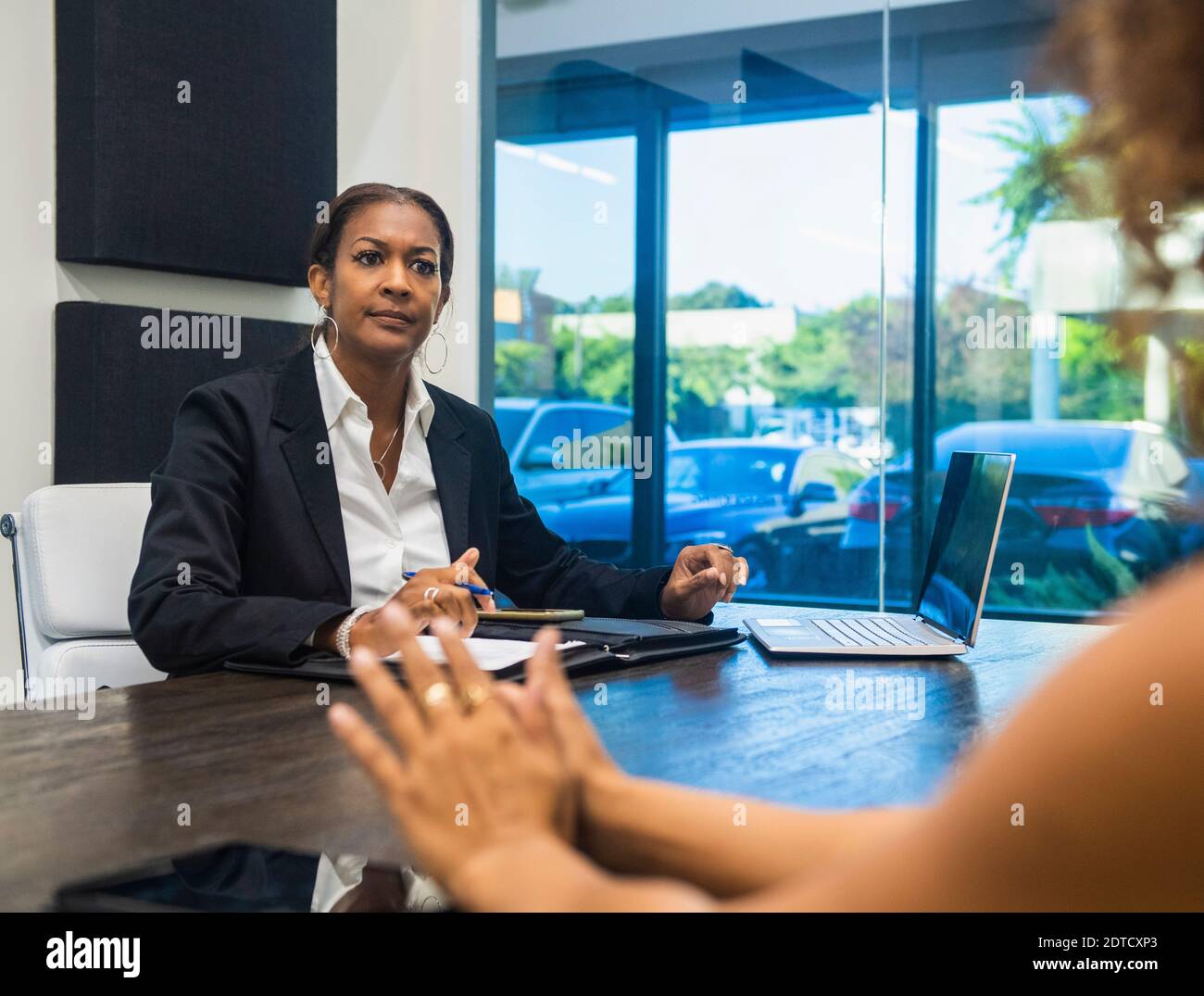Two businesswomen talking at conference table Stock Photo