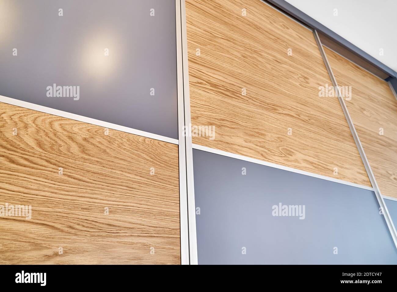 Wooden wardrobe door panels made of light brown natural oak timber with elegant texture patterns and blank grey parts Stock Photo