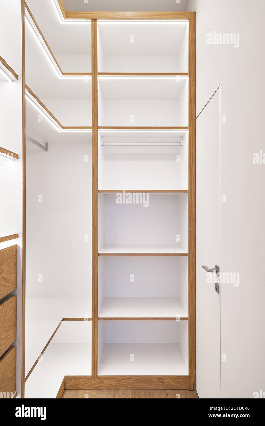 Elegant white shelving with LED lighting. Shelving of laminated boards
