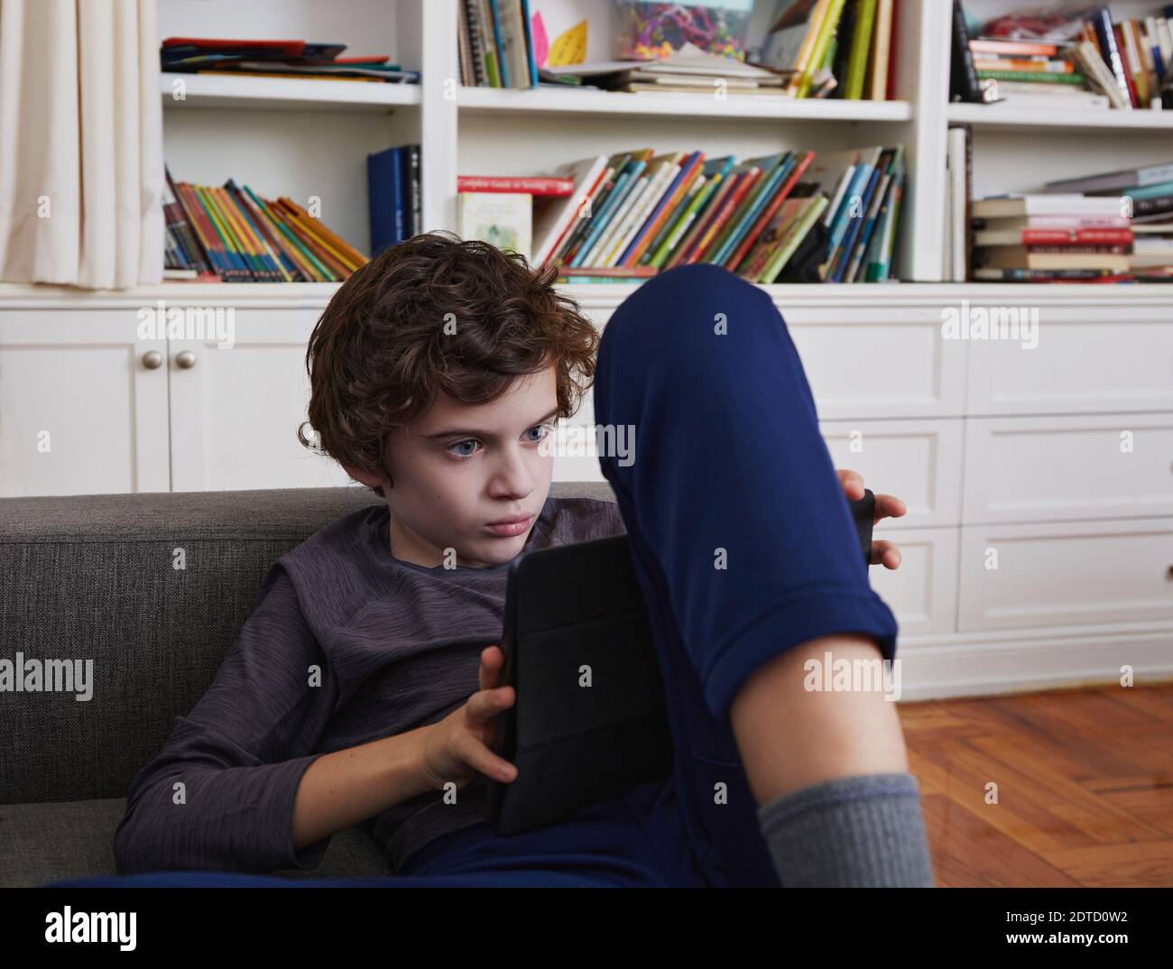 Boy (8-9) using tablet at home Stock Photo