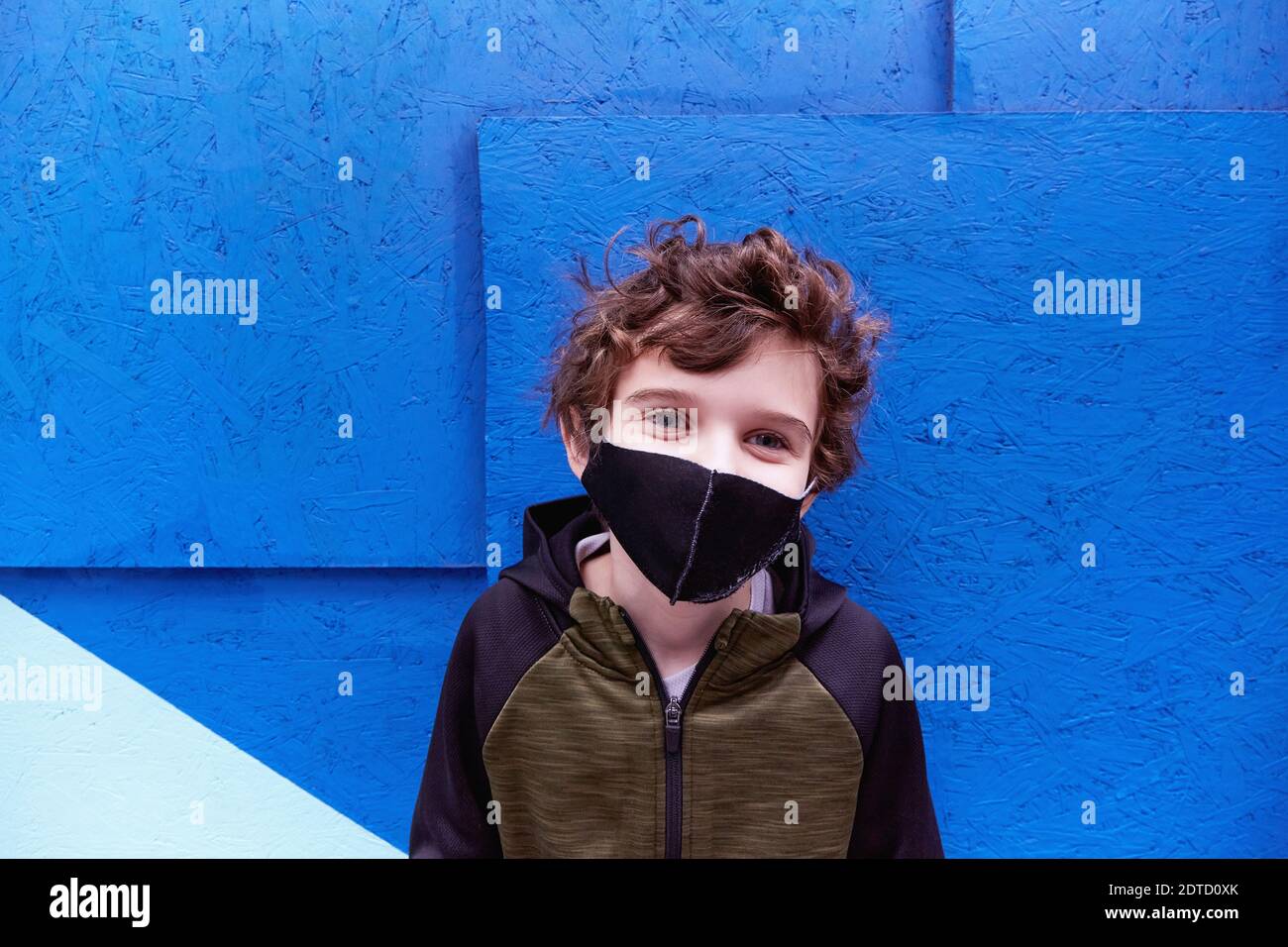Boy (8-9) wearing protective face mask Stock Photo