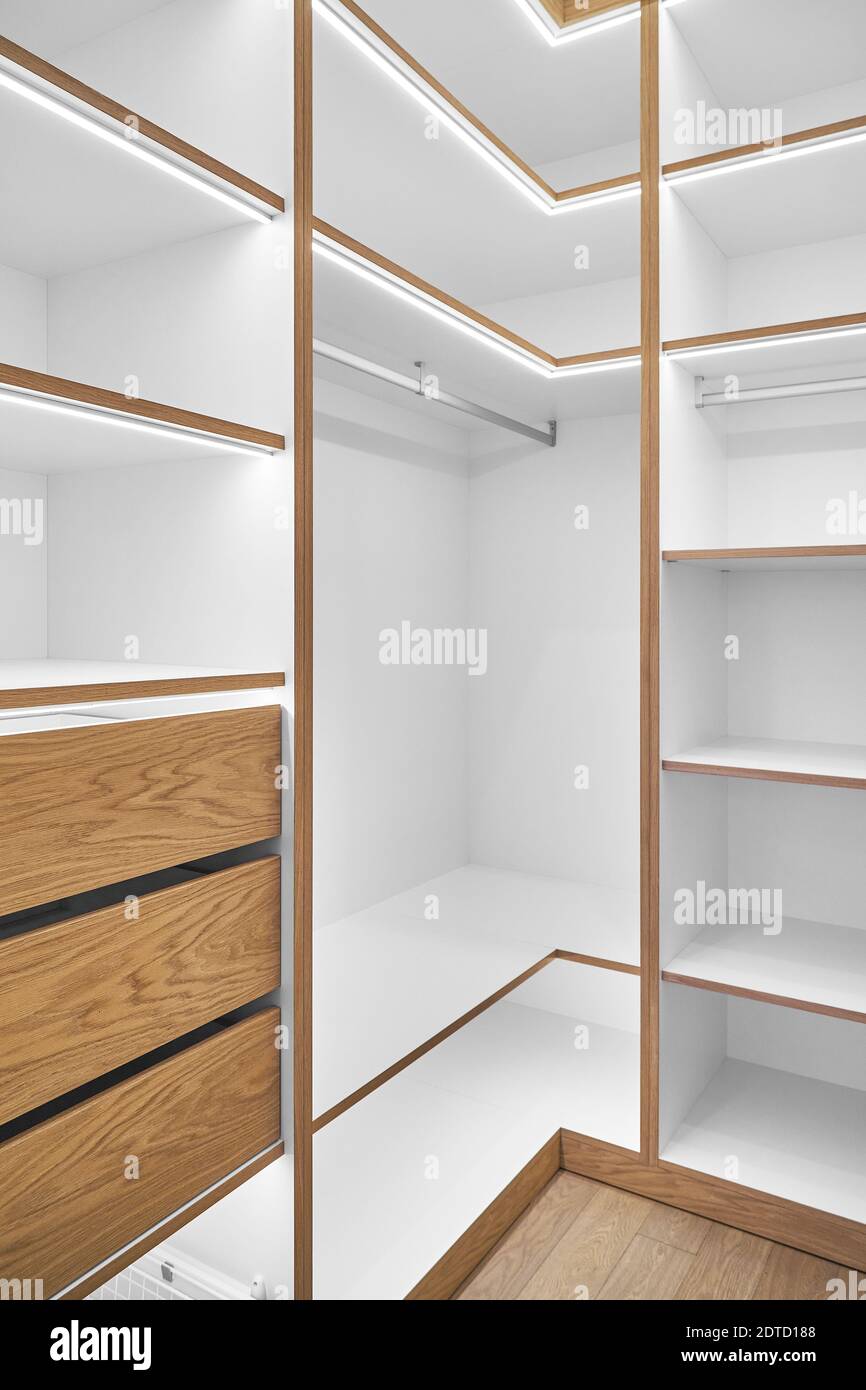 Elegant white shelving with LED lighting. Shelving of laminated boards