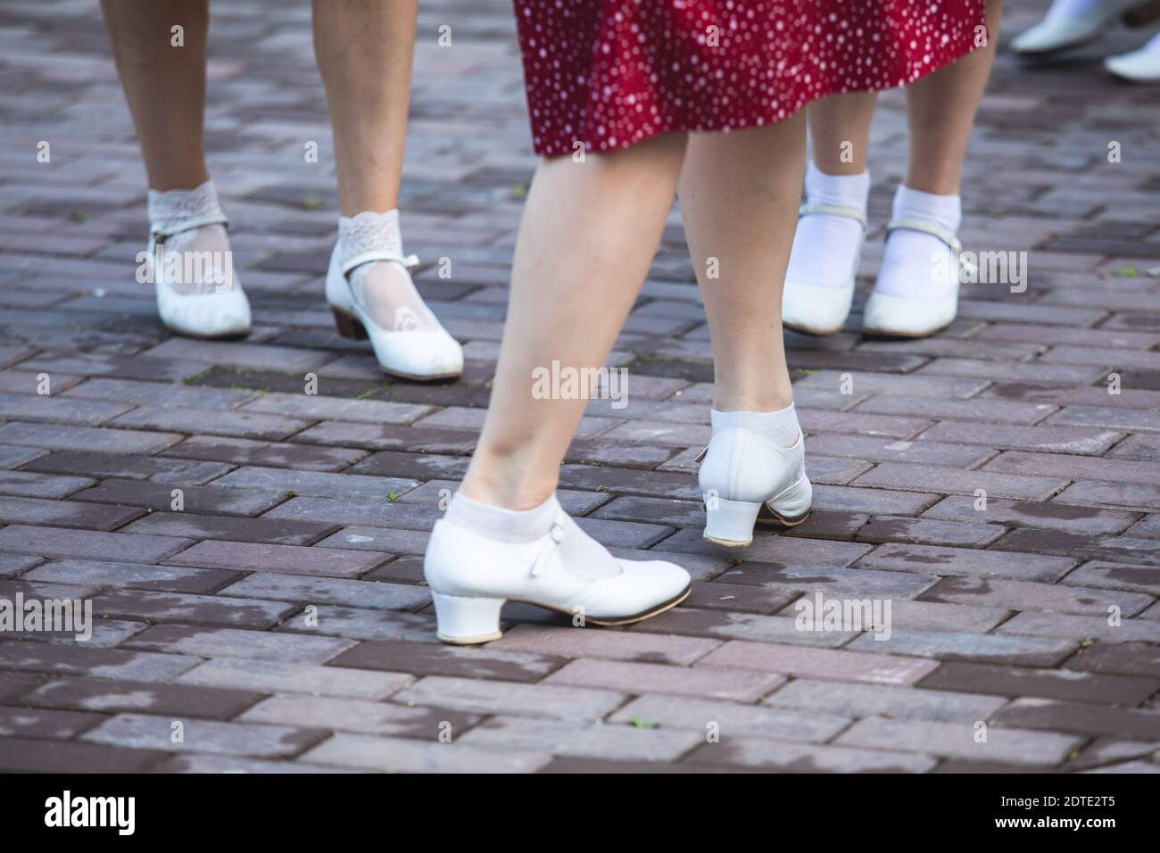 Young women wearing vintage polka dot dresses dancing in city park, close  up view of same black dancing shoes and white socks, female retro jazz  swing Stock Photo - Alamy
