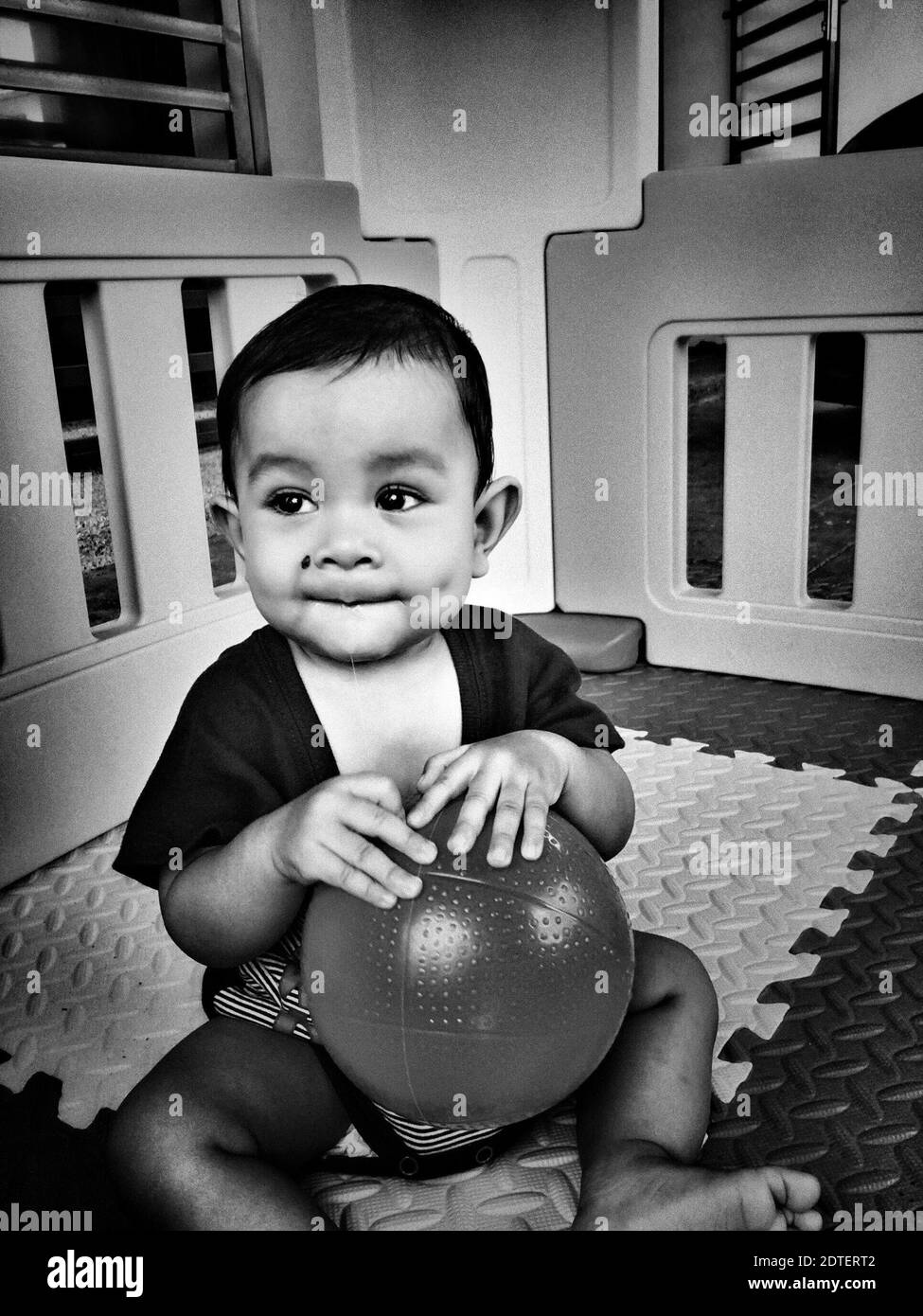 Baby boy holding ball Black and White Stock Photos & Images Alamy