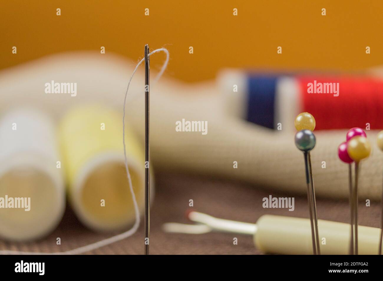 Threads and needle as wallpaper or background Stock Photo - Alamy