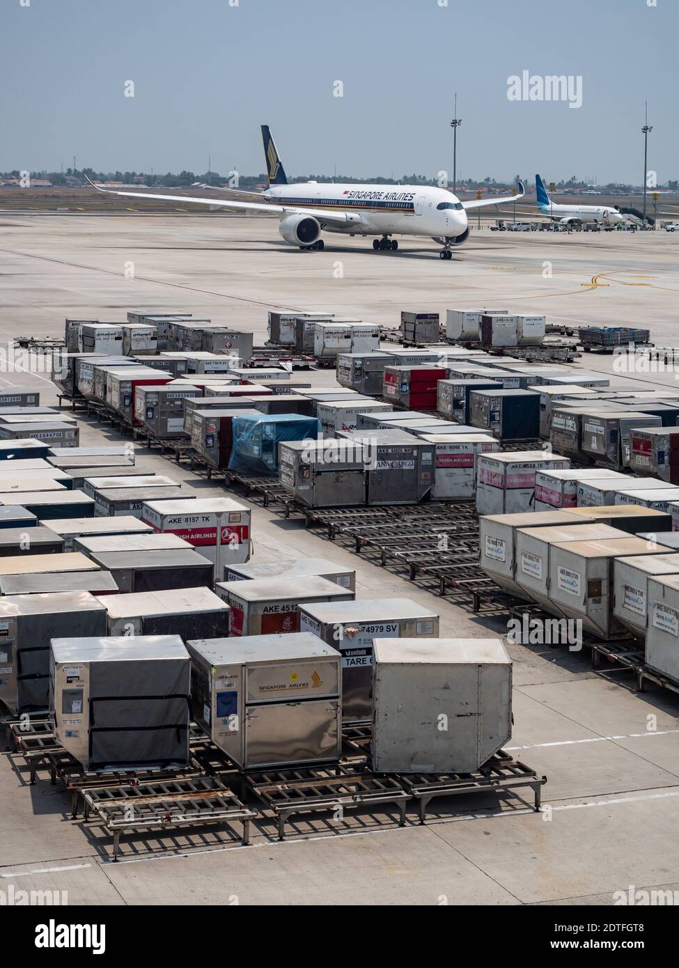 Luggage containers at Terminal 3, Soekarno–Hatta International Airport in Jakarta, Indonesia. Singapore Airlines Airbus A350 and Garuda Indonesia Boei Stock Photo