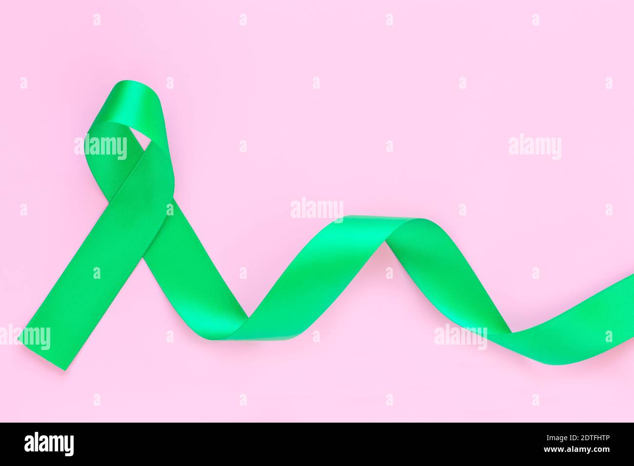 Top view of emerald green ribbon on dark wood background. Liver cancer  awareness concept Stock Photo - Alamy