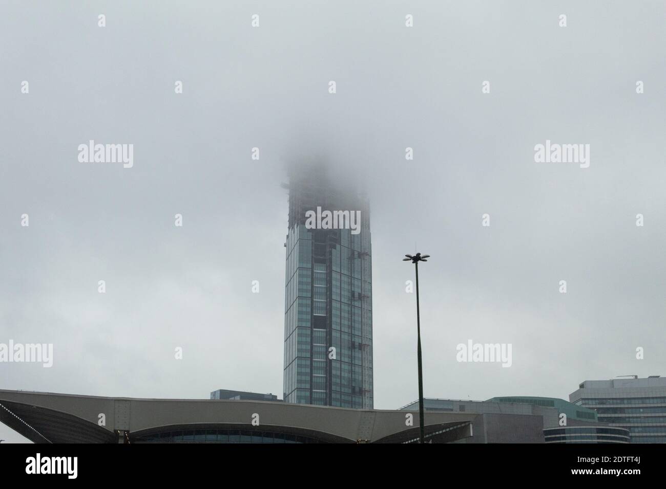 Construction of a skyscraper in the rain. Skyscraper and clouds with