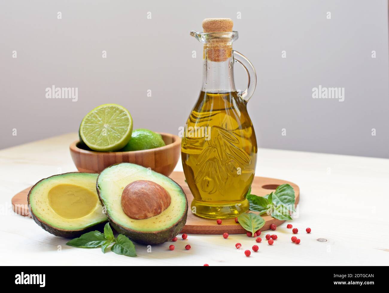 Concept of vegetarian food with avocado, limes and olive oil on white background. Stock Photo