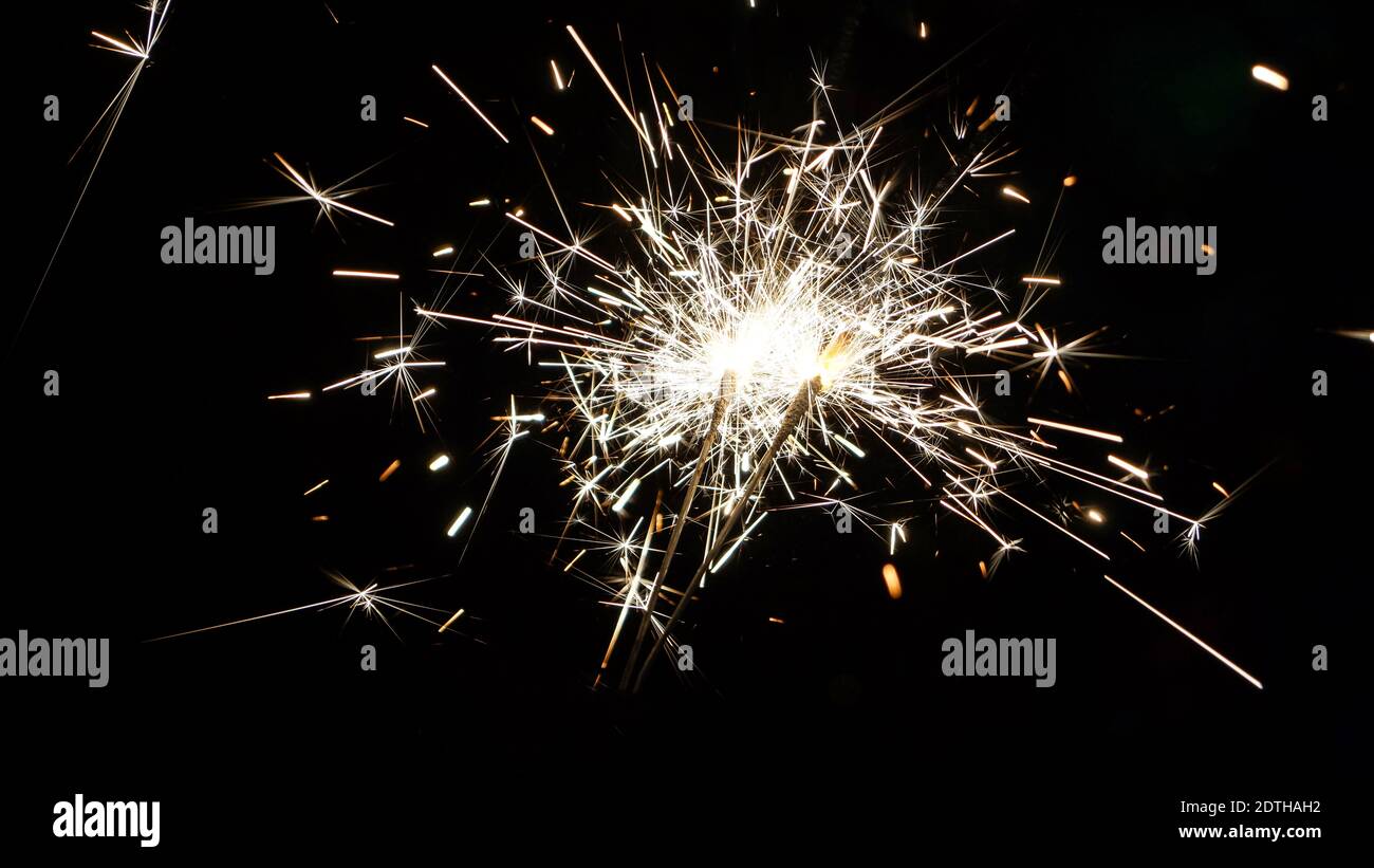 Christmas sparklers glow with sparks in the dark Stock Photo Alamy
