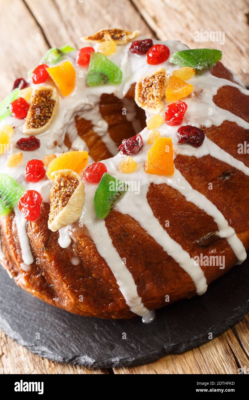Delicious cake with dried fruits and icing close-up on the board on the table. vertical Stock Photo