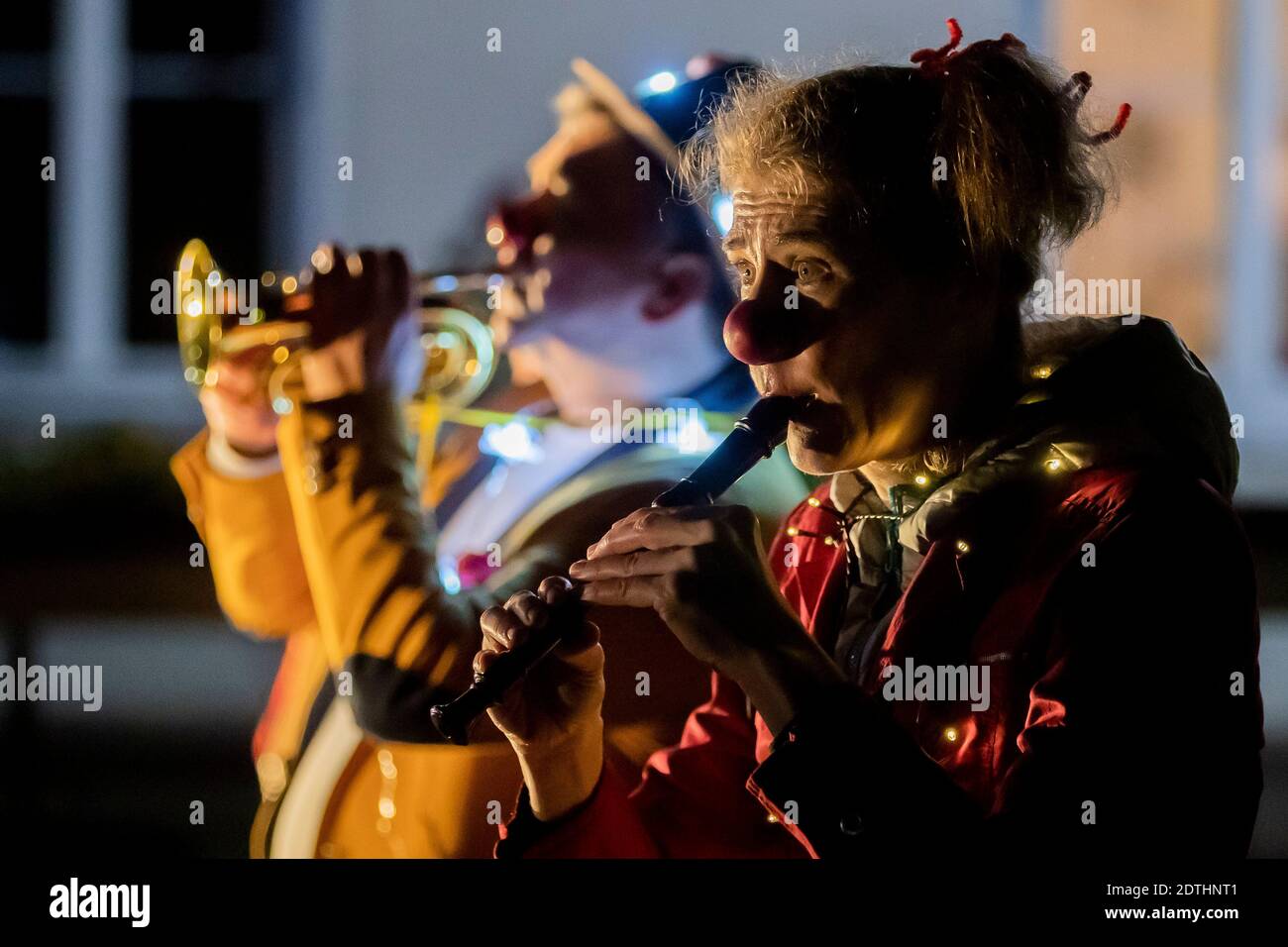 21 December 2020, Brandenburg, Jüterbog: Tanja Selmer as the clown "Tiffy"  and Andreas Böhlke as the clown "Tute Caruso" make music during a Christmas  performance by clinic clowns from the Potsdam association "