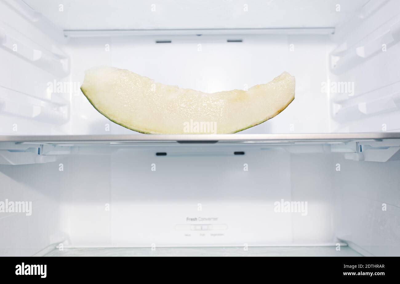 A healthy juicy melon full of vitamin placed on shelf inside modern empty refrigerator Stock Photo