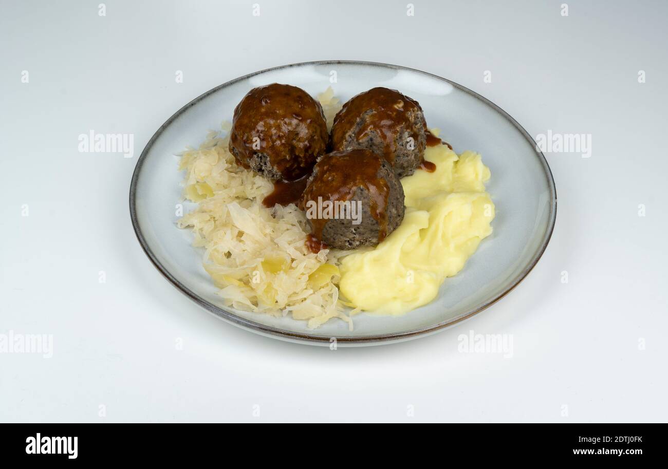 Eine Portion gekochter, pfälzer Leberknödel mit Sauerkraut, Kartoffelpüree und brauner Sauce, Stock Photo