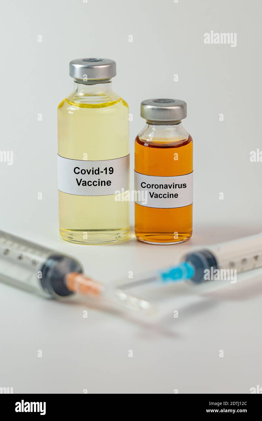 Vertical photo of coronavirus vaccine bottles and syringe injection ...