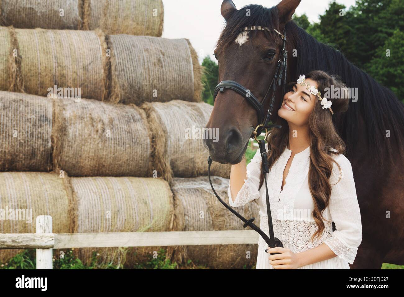 Cute young woman and her beautiful horse take a walk in the countryside