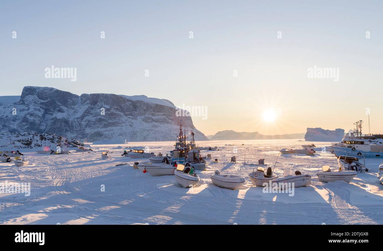 Town Uummannaq during winter in northern Greenland. Ships in the frozen harbour. America, North America, Denmark, Greenland Stock Photo