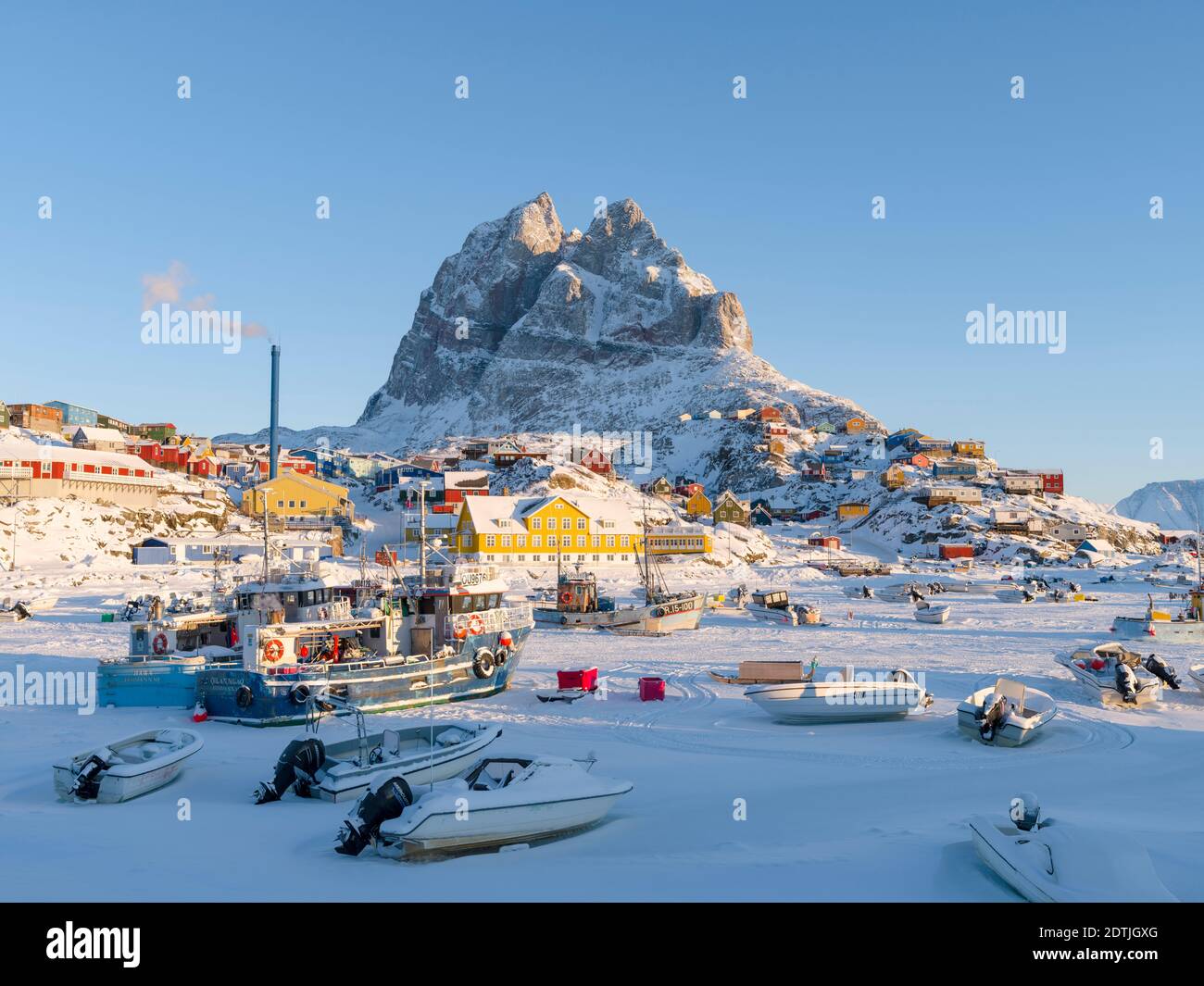 Town Uummannaq during winter in northern Greenland. Ships in the frozen harbour. America, North America, Denmark, Greenland Stock Photo