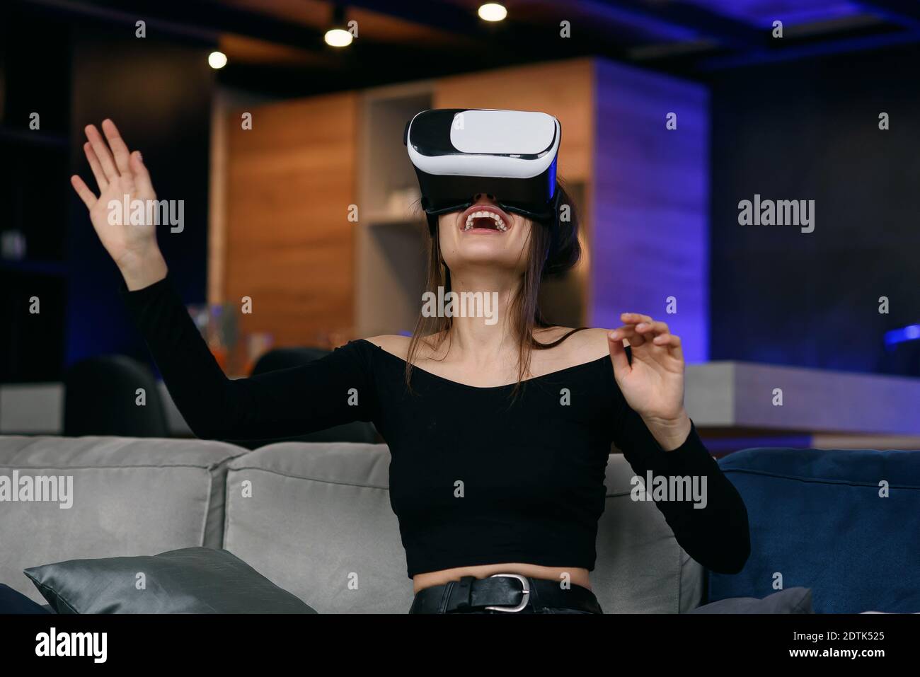 Virtual Reality concept. Excited beautiful adult girl uses VR Headset  playing video game at stylish cozy living room Stock Photo - Alamy
