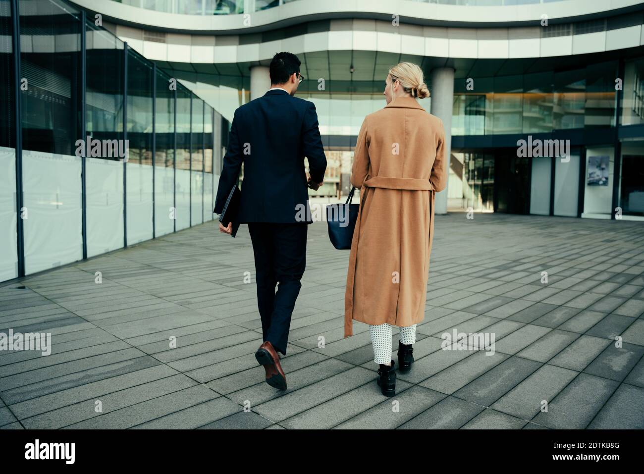 Business colleagues walking to work bonding while talking about clients Stock Photo