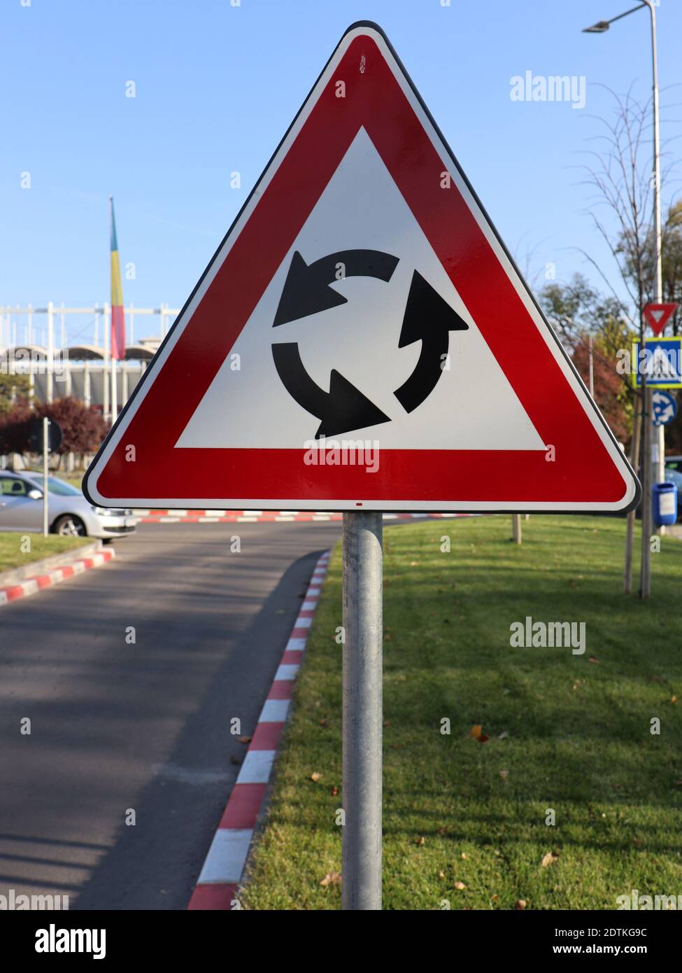 A vertical shot of the circular intersection road traffic sign on the