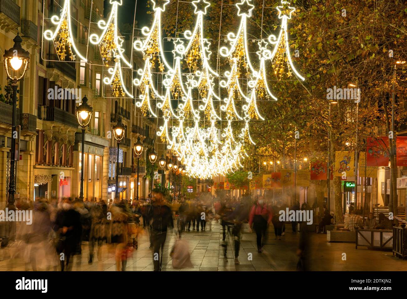 barcelona, spain - 21 december 2020: christmas shopping time in barcelona portal de l'angel street. crowd at night doing christmas shopping with chris Stock Photo