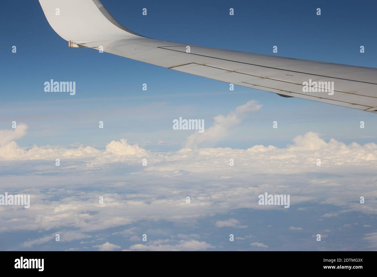 A wing of an airplane flying over a cloudy sky Stock Photo - Alamy