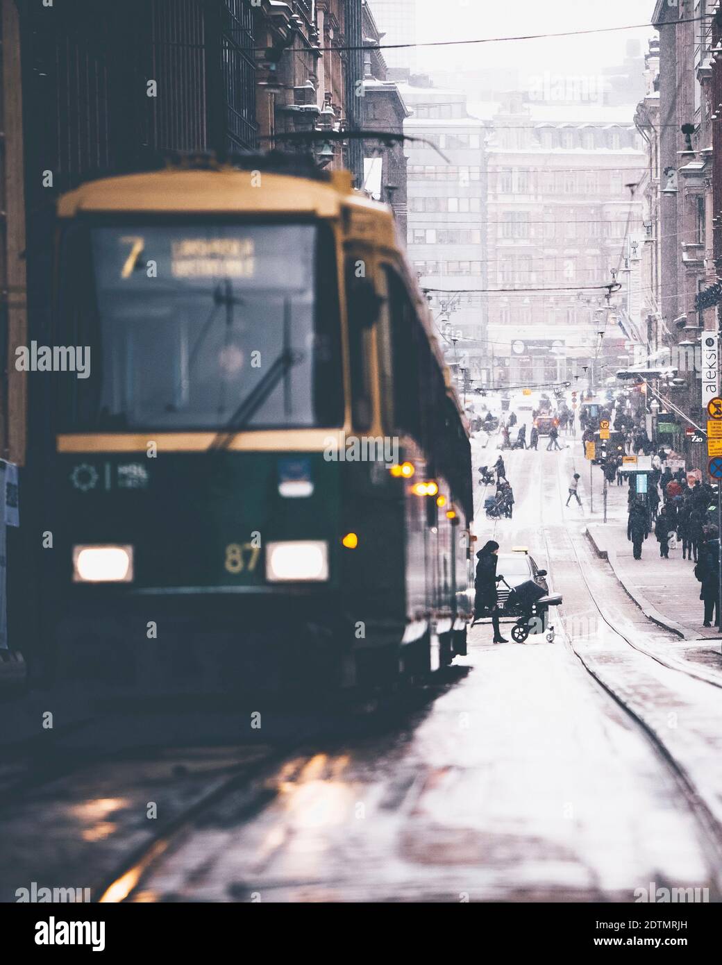 A tram in Helsinki, Finland. In the background a mother with a pram Stock Photo