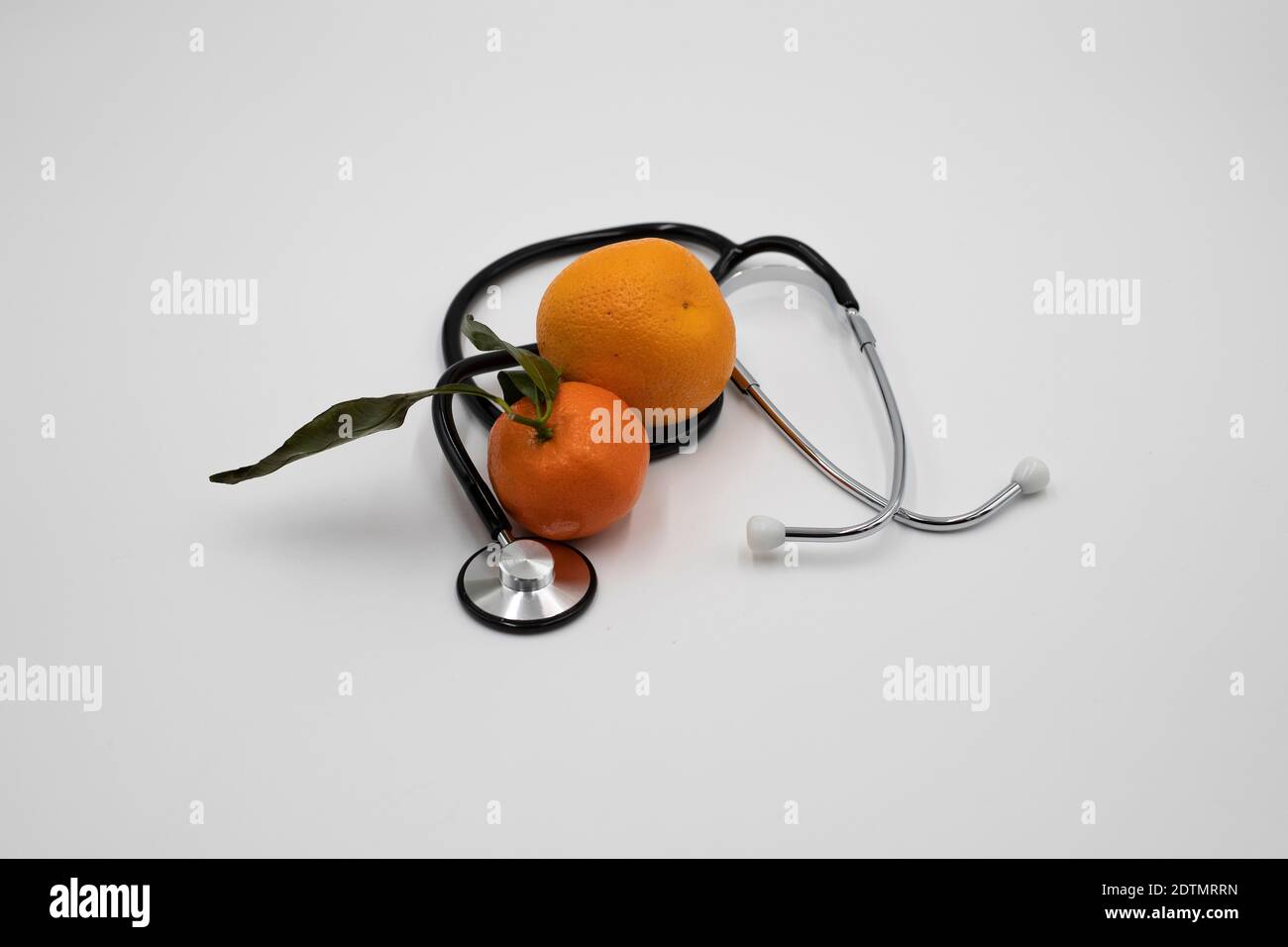 Orange and stethoscope on a white bacground Stock Photo