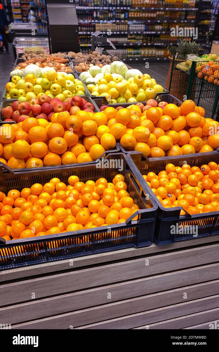 Tangerines, oranges, apples and other fruits are sold in the store. Vertical image. Stock Photo