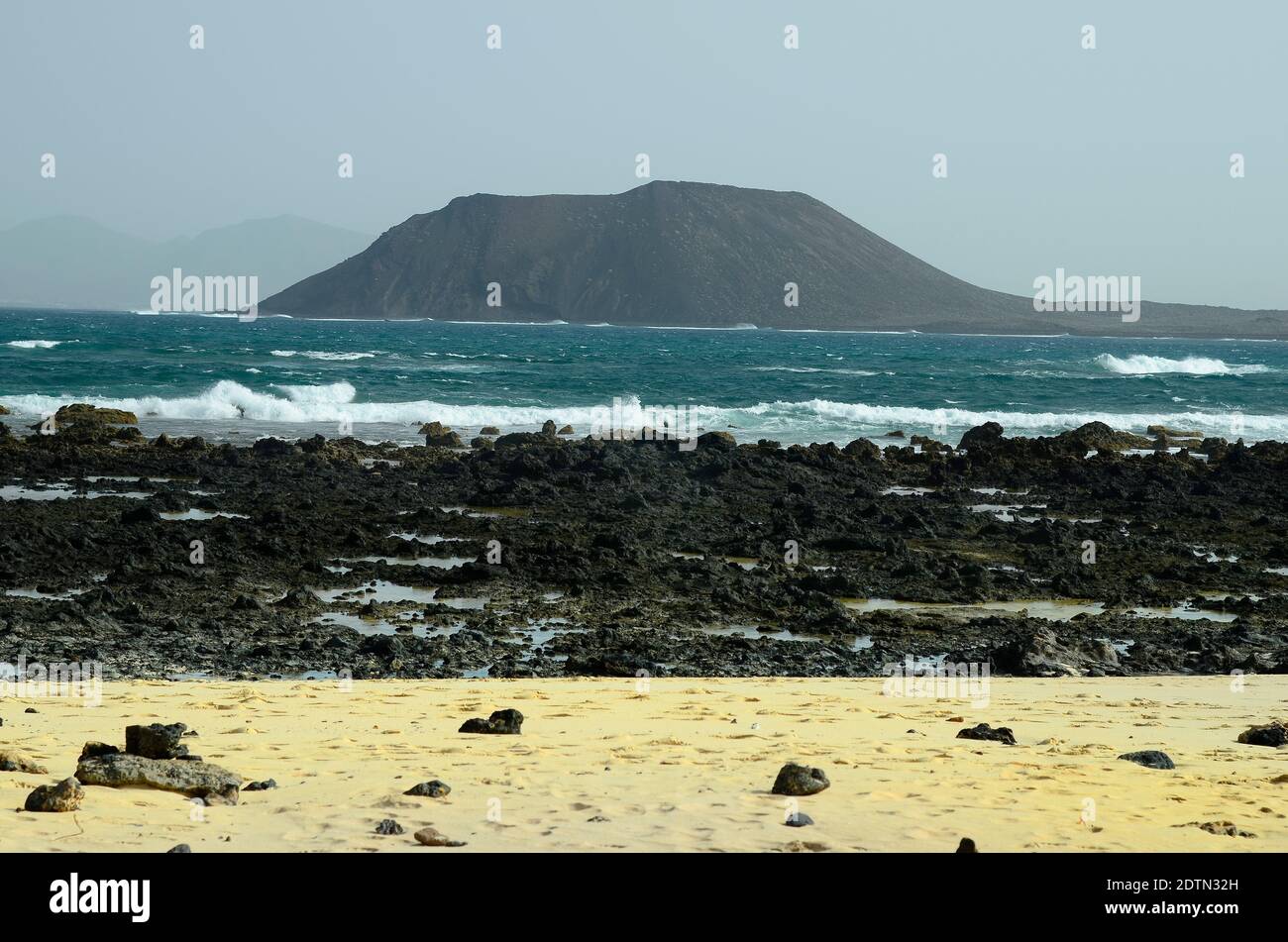 Spain, Canary Island, Fuerteventura, rocky coast with Los Lobos island behind Stock Photo