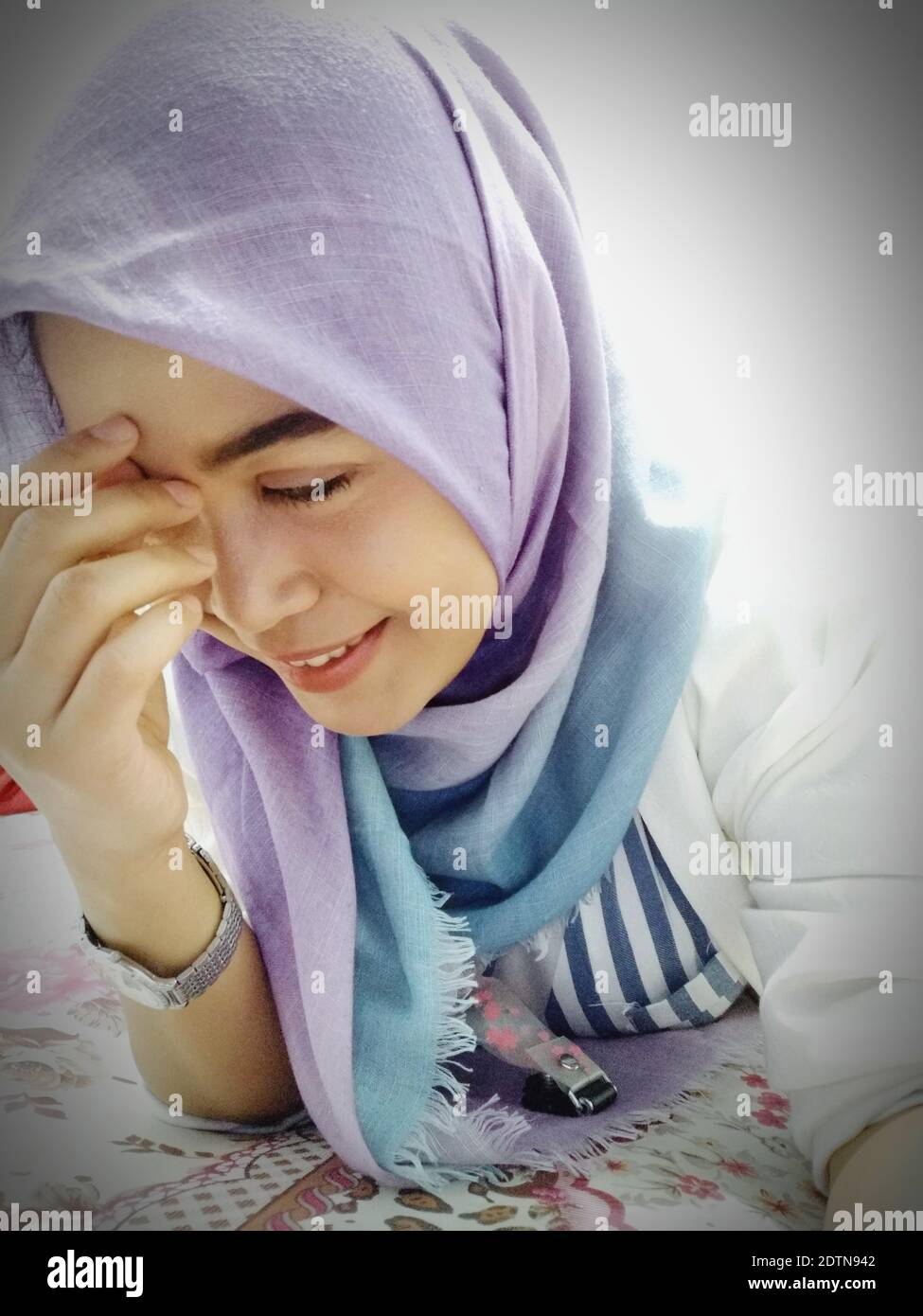 Portrait Of A Smiling Young Woman Lying On Bed Stock Photo - Alamy
