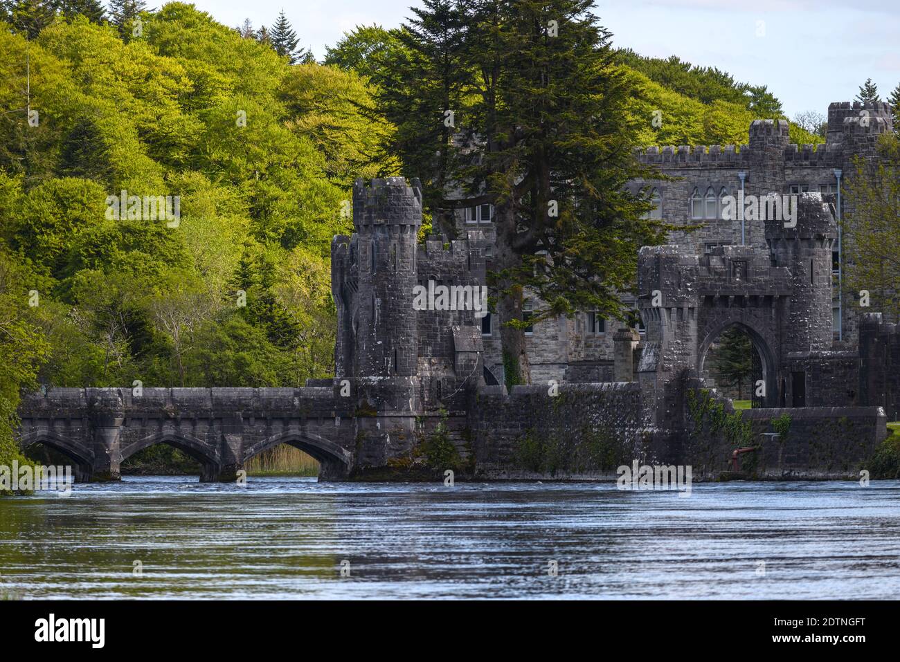 Ashford castle with stone bridge, river and forest, located near Cong