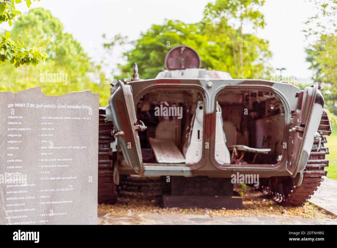 A tank sits at an urban park as a memorial for those who