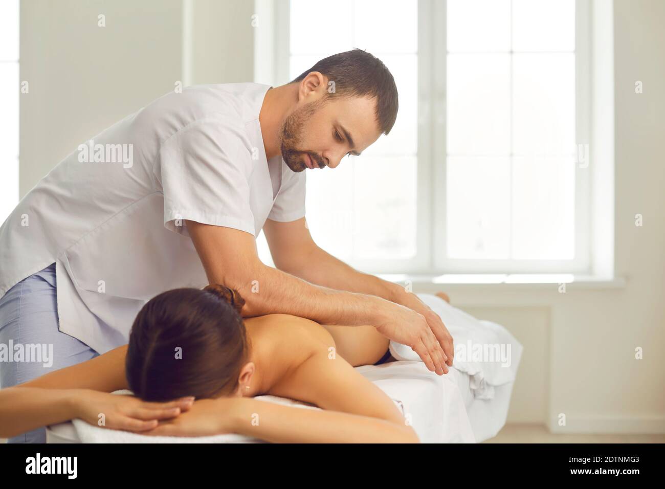 https://c8.alamy.com/comp/2DTNMG3/professional-massagist-doing-back-massage-for-young-woman-lying-on-massage-table-2DTNMG3.jpg