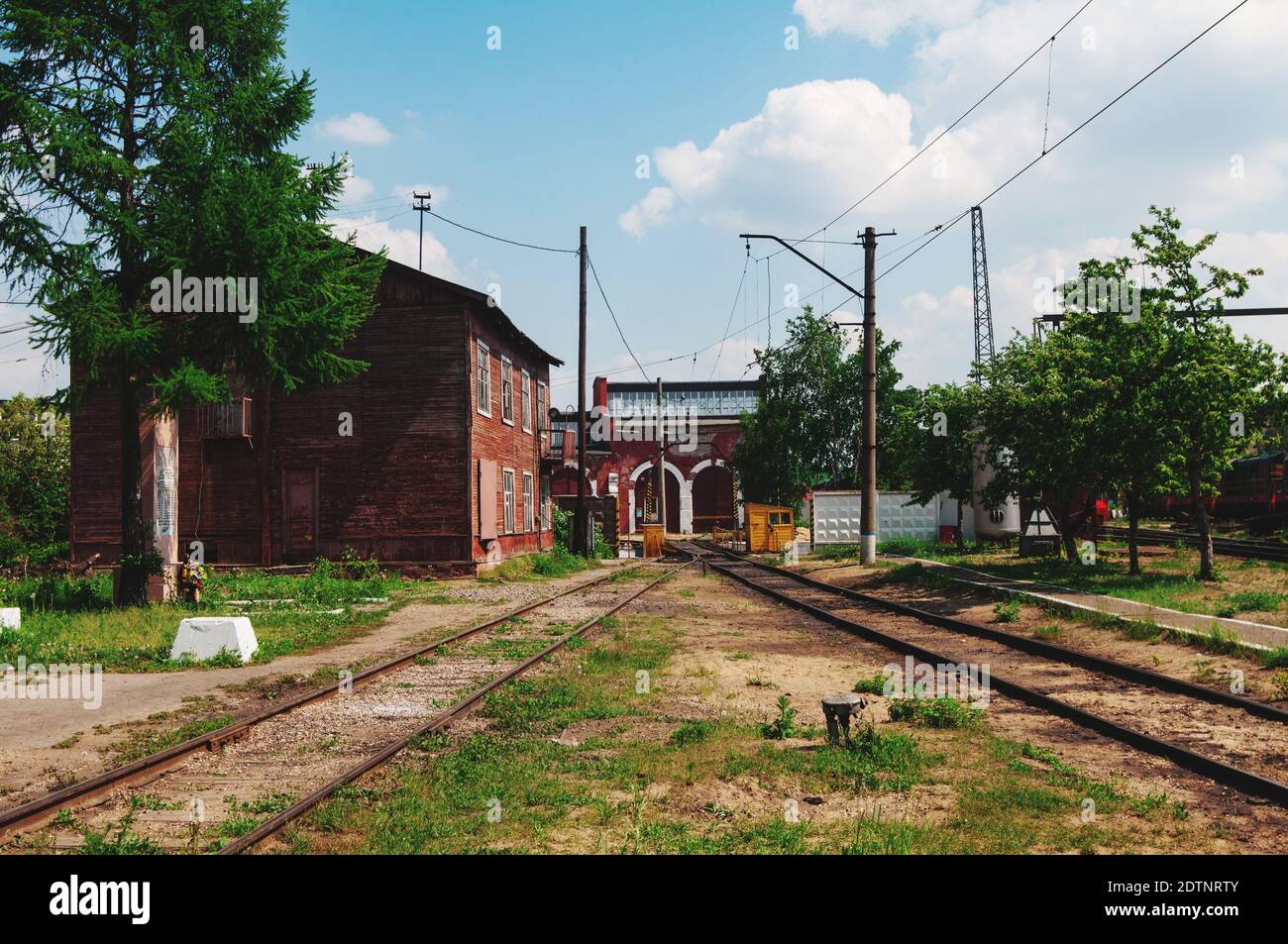 Railroad Tracks By Trees And Buildings Against Sky Stock Photo