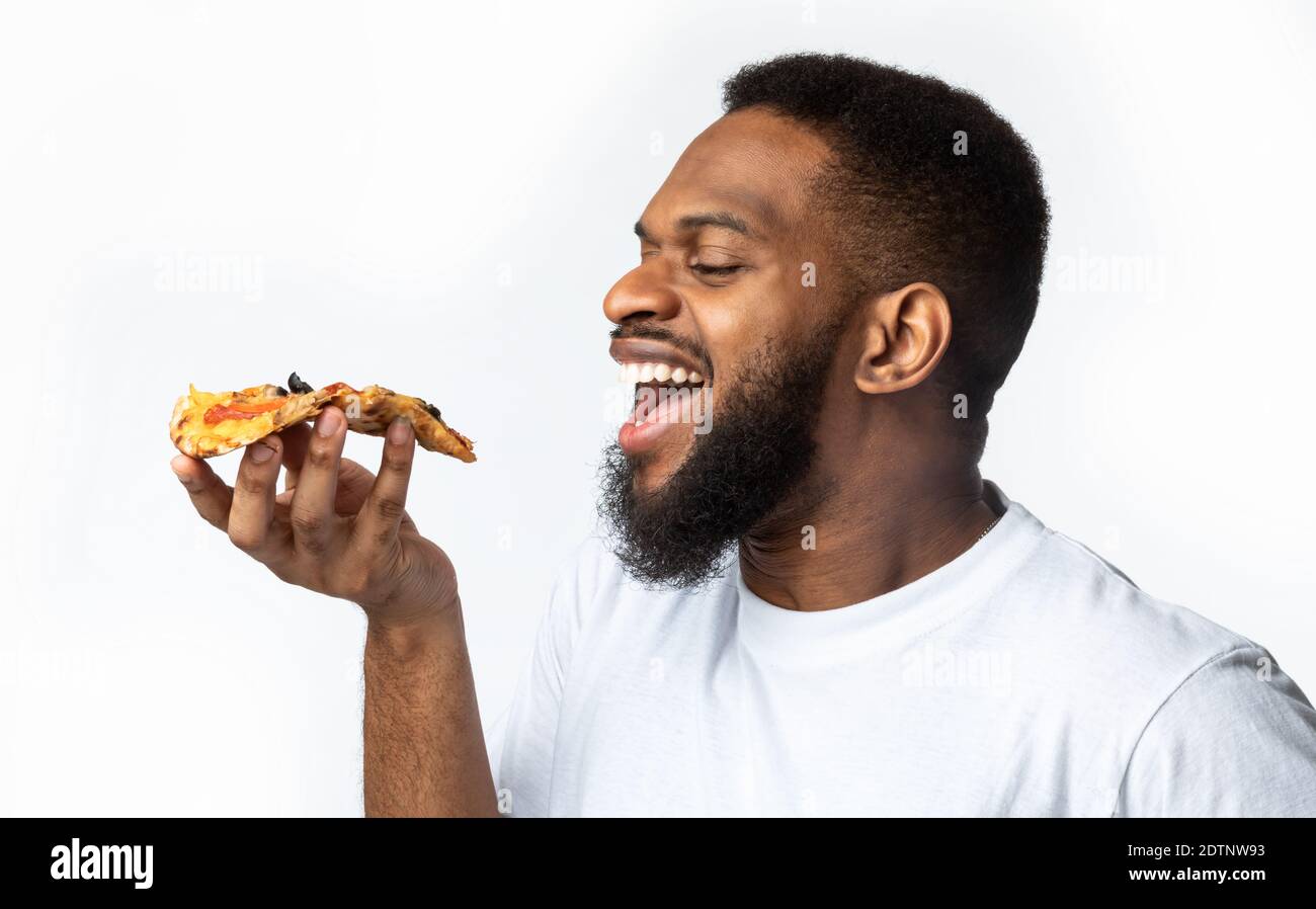 Happy african american friends eating pizza at home Stock Photo by  Prostock-studio