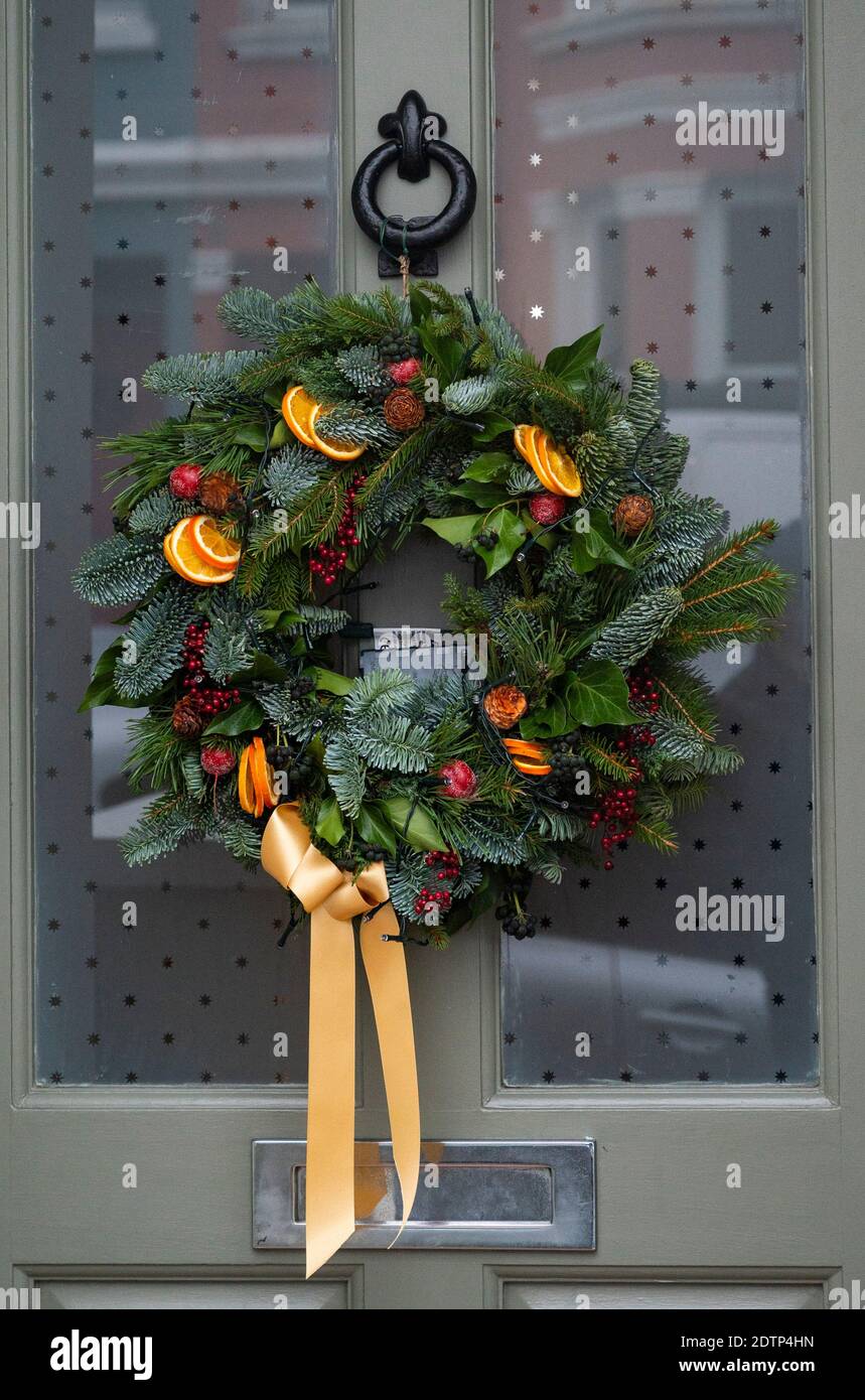 Brighton UK 22nd December 2020 - Christmas wreath decorations hanging on doors in the Queens Park area of Brighton Credit Simon Dack / Alamy Live News Stock Photo