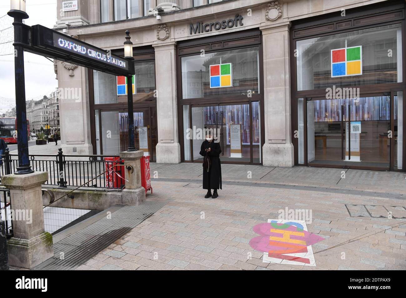 A woman stands outside the closed Microsoft store at Oxford Circus underground station, central London, where people have been advised against all but essential travel after the capital moved into Tier 4 of coronavirus restrictions. Stock Photo
