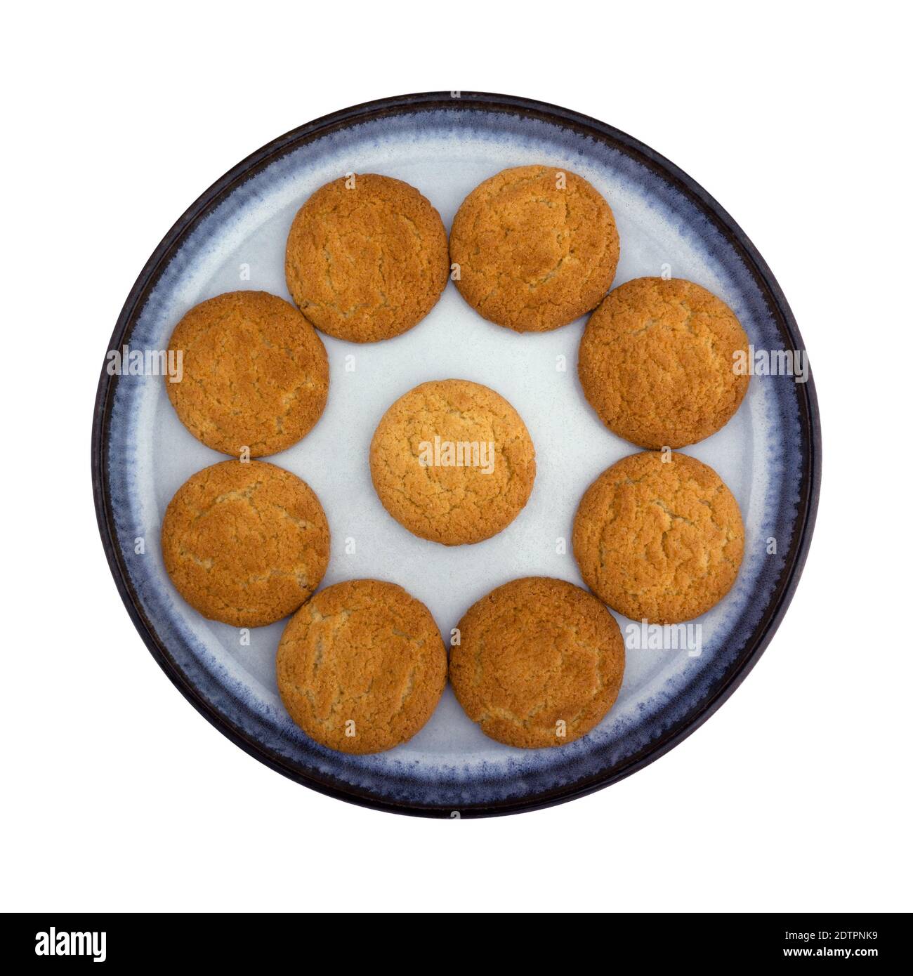 Top view of a group of coconut flavor cookies arranged on a blue stoneware plate isolated on a white background. Stock Photo