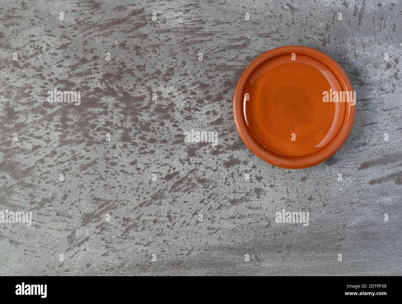 Bowl of light corn syrup offset on a gray mottled background illuminated with natural lighting. Stock Photo